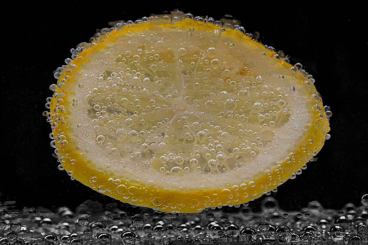 Close-up of natural fruit smoothie enhancer powder being sprinkled into a glass of smoothie